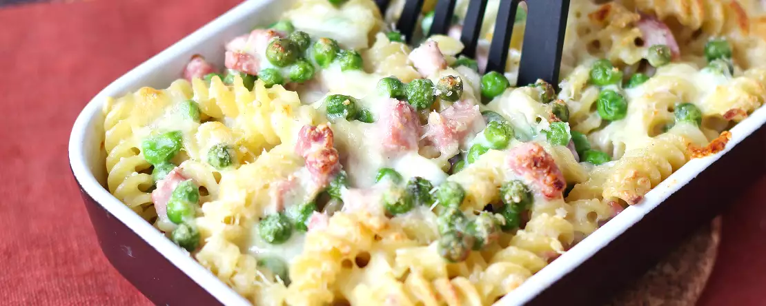 Krämigt bakad pasta med ärtor och gratinerad skinka