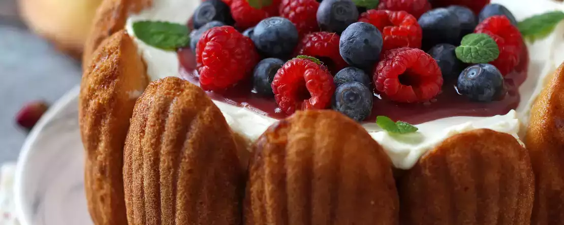 Charlotte med röd frukt och madeleines