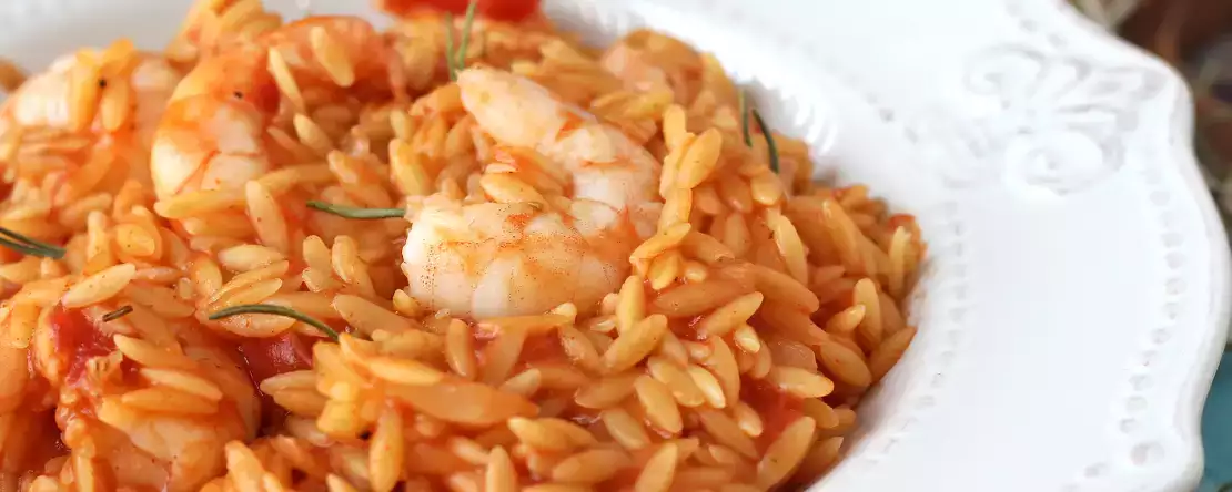 Orzo-pasta med tomater och räkor, tillagad som en risotto